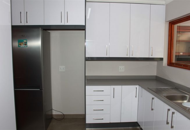 Scullery area in Gloss Iceberg White and Gloss Storm Grey melamine and Grey Quartz tops