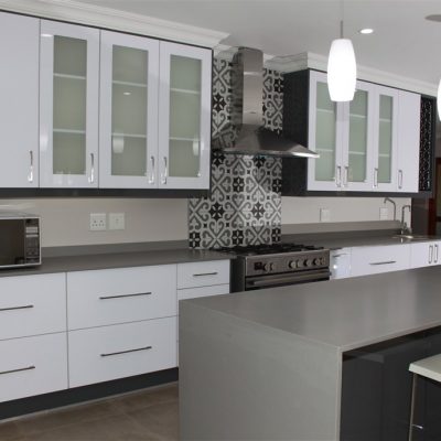 New Kitchen done in Gloss Iceberg White and Gloss Storm Grey melamine and Grey Quartz tops Frosted glass doors