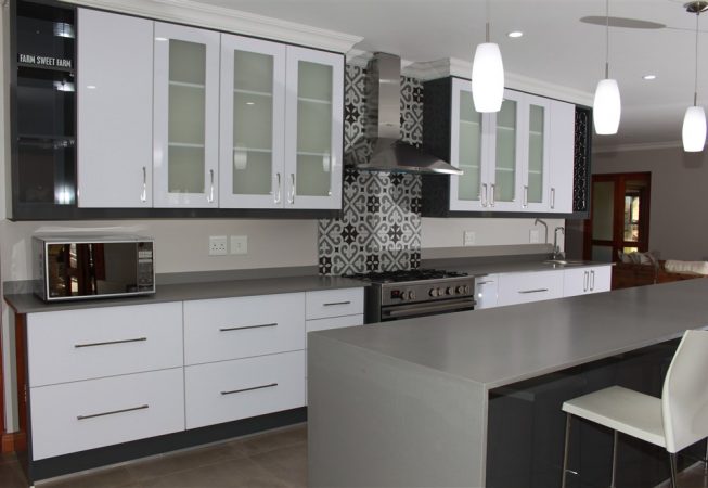 New Kitchen done in Gloss Iceberg White and Gloss Storm Grey melamine and Grey Quartz tops Frosted glass doors