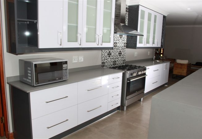New Kitchen done in Gloss Iceberg White and Gloss Storm Grey melamine and Grey Quartz tops Frosted glass doors