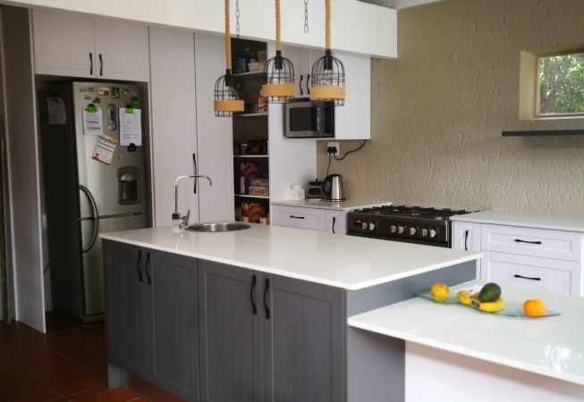 White melamine with white shaker wrap doors and Vanilla quartz tops Island unit in Storm Grey