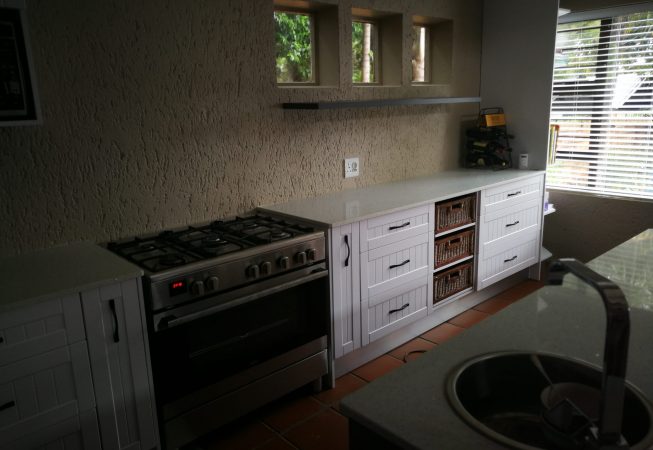 White melamine with white shaker wrap doors and Vanilla quartz tops