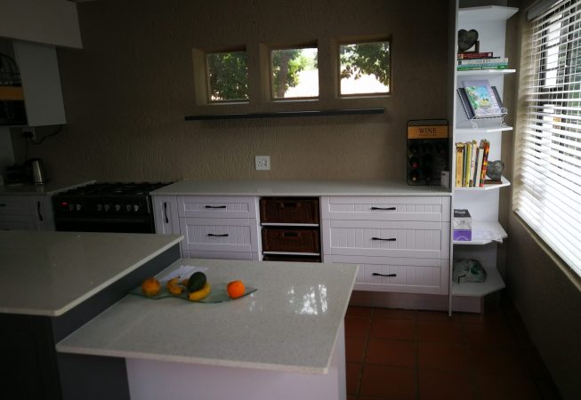 White melamine with white shaker wrap doors and Vanilla quartz tops