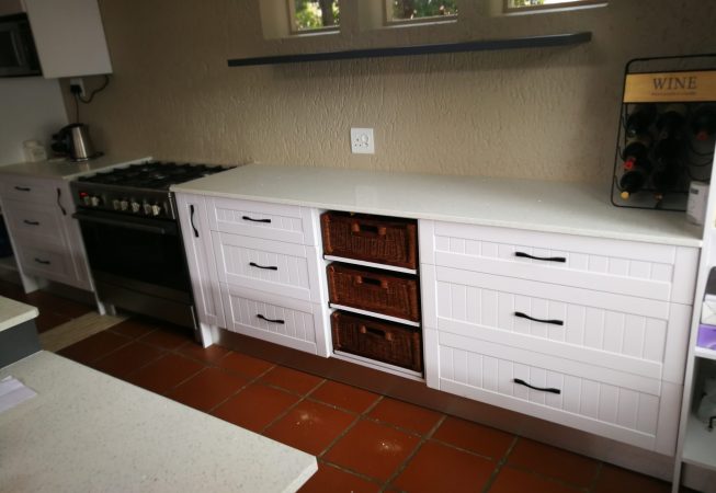 White melamine with white shaker wrap doors and Vanilla quartz tops