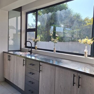 Greythorne and Strom Grey melamine cupboards and Rustenburg granite countertop with frosted glass door.